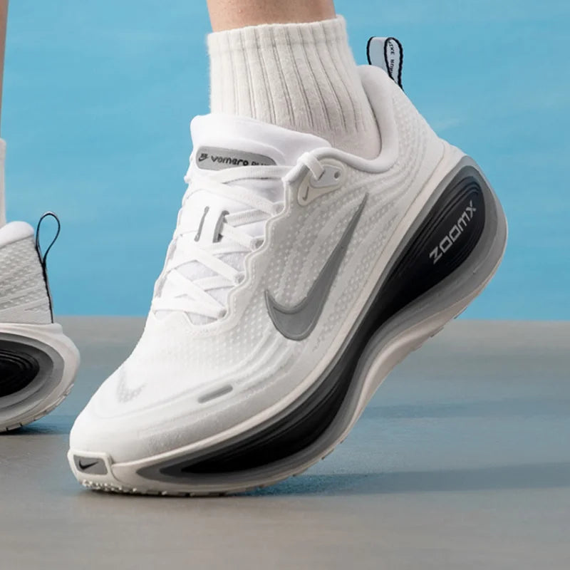 White athletic shoe with black sole on a light blue background